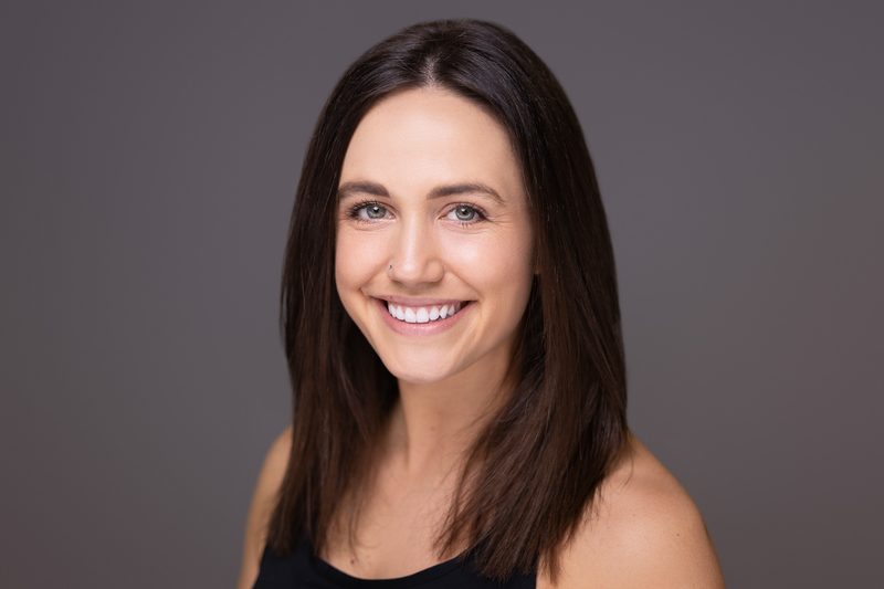 Studio headshot of a smiling woman on a white background