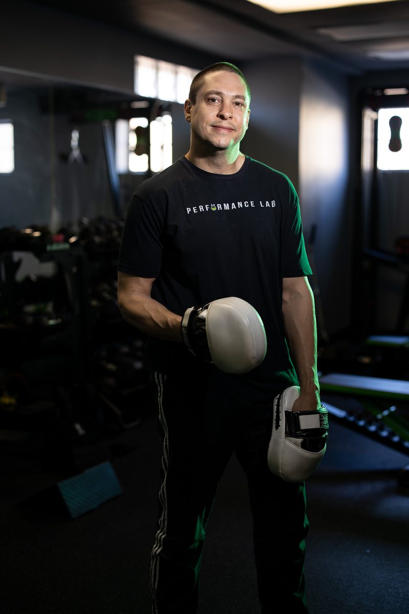 Environmental portrait of a bearded male trainer with a kettlebell